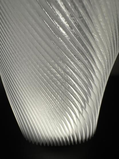 Close up of a 3D printed lamp shade showing the curvy design.