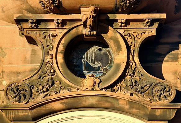 A sculptural decoration above the entrance to a late Victorian bank building.