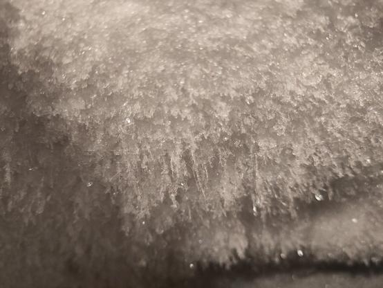 Thin crystals of ice growing from the side of a wall