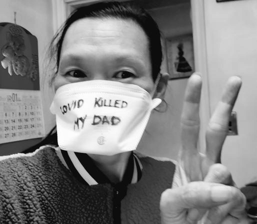 Monochrome selfie of me, wearing white N95 face mask. With: Covid Killed My Dad - written in black marker on it.