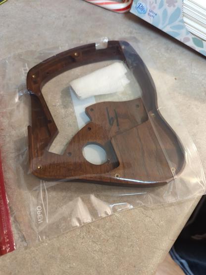 The wooden shell if the left side of a Keyboardio Model 100 keyboard, in a ziplock bag with a wet paper towel.