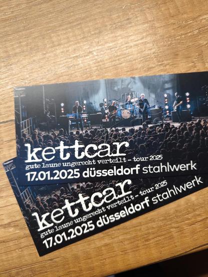 Zwei Konzert Tickets auf einer Arbeitsplatte.