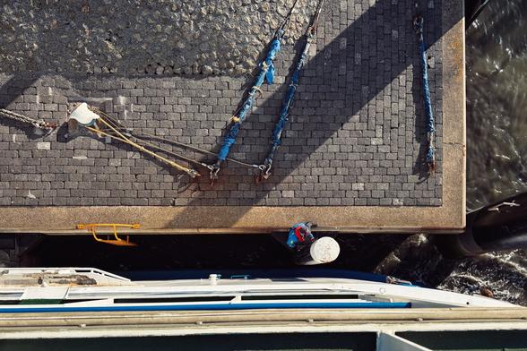 A harbour worker is seen on the edge of the mooring place of the ferry from Terschelling to Harlingen. The photo is taken from the upper deck of the ferry and simulates a bird‘s eye view perspective.