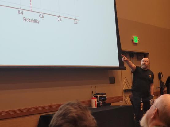 Gary pointing at some probability data on his slides projected on the screen.