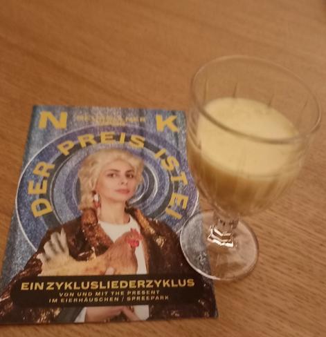Flyer des Stückes neben einem Gläschen Eierlikör