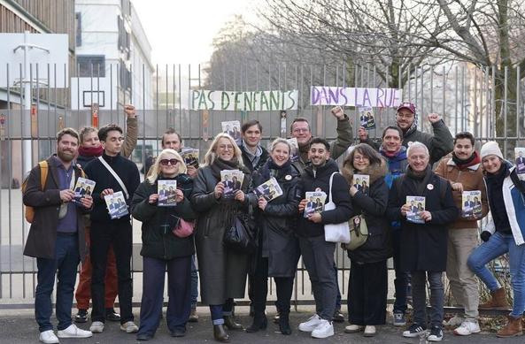 Un groupe de militants debout devant un terrain de sports (ou cour d'école). Au milieu on reconnaît Lucie Castets et Danielle Simonnet. À l'arrière, sur la grille de la cour d'école, une banderole "Pas d'enfants à la rue"