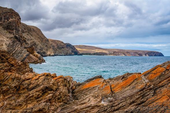 Second Valley, South Australia - interesting rocks in the foreground, the ocean in the middle and hills and cliffs in the background.