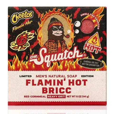 A picture of a bar of soap package it says:

DR. Squatch. Limited Edition. Men's Natural Soap. Flamin' Hot Bricc.

Red cornmeal. HEAVY GRIT. NET WT 5oz (141g)

There are also various logos on it like the Cheetos Flamin' Hot logo, a mini flame with arms and a face smiling, a flaming sphere saying "smell the squatch, and a warning that says "!EXTERNAL USE ONLY NOT FOR CONSUMPTION!"