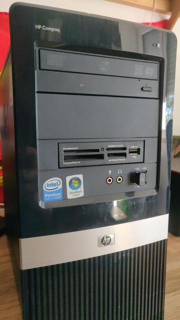 A black HP Compaq desktop computer tower is shown.  The front features a DVD-RW drive, card readers for SmartMedia/xD, CompactFlash I/II, SD/MMC+/miniSD, and MS PRO/MS PRO Duo cards, and USB 2.0 ports.  Audio jacks and a small USB port are visible below the card readers.  The tower also displays Intel Pentium Dual-Core Inside and Windows Vista logos.  The HP logo is present at the bottom.