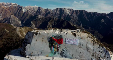 Photo: Des militants écologistes ont mis un bandeau sur le graffiti Michelangelo, attraction touristique qui a été peinte sur une #carrière de #marbre. La banderole dit « la dévastation n’est pas de l’art »