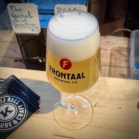 A Frontaal branded tasting glass filled with a pale ale on the bar, Brouwerij Kees stickers next to it