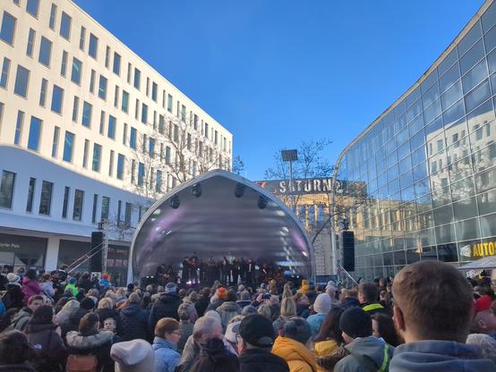 Photo
Many people front of a stage. The stage is between two 6 levels high buildings.