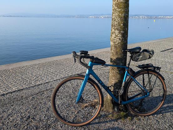 Mein Fahrrad an einen Baum gelehnt. Im Hintergrund der See.