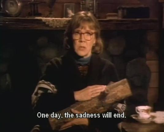 a still of the log lady with sans along the bottom that reads, "One day, the sadness will end."