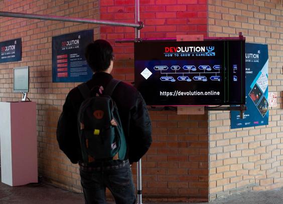 Man looking at a monitor in a bigger exhibition space, looking at the timeline visualisation of a game.