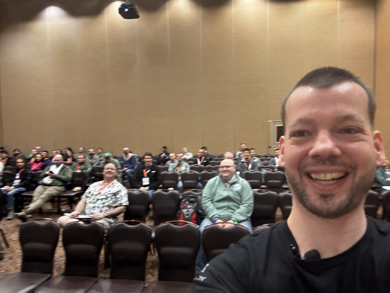 Josh stands in front of his audience to take a selfie