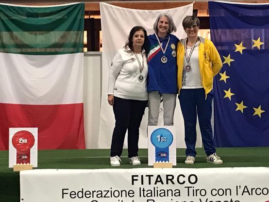 Podio dei campionati regionali del Veneto, con le arciere che si abbracciano. Sul gradino più alto l'atleta degli Arcieri del Pasubio