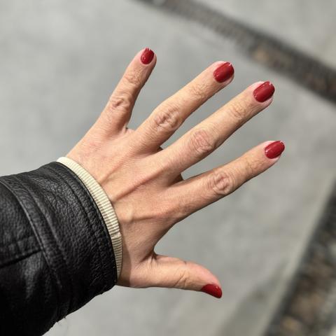 Mano derecha extendida con unas uñas rojas preciosas!