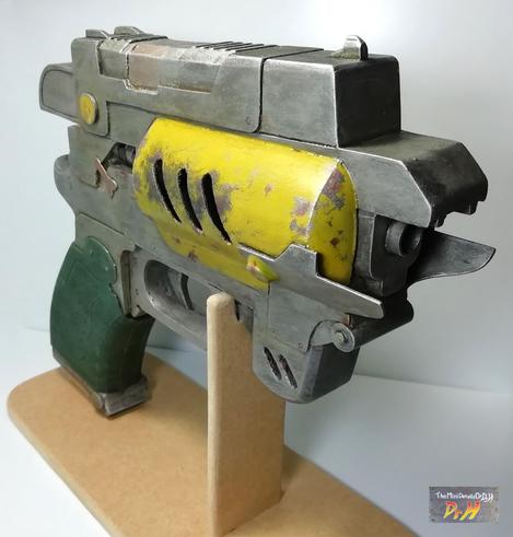 The Outer Worlds pistol prop replica on display stand from front right.