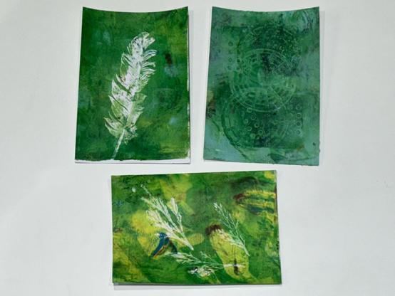 Left: A white feather on a green background
Links: Eine weisse Feder auf einem grünen Hintergrund
Right: A green background with circles with patterns
Rechts: Ein grüner Hintergrund mit Kreisen mit Mustern
Below: Green and yellowish background with white small twigs as print
Unten: Grüner und gelblicher Hintergrund mit weissen kleinen Zweigen als Druck