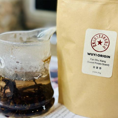 A photo of the packaging from Wuyi origin. Next to it is the tea in a clear pot