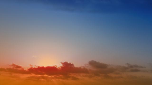 Sun behind red clouds in a blue and orange sunset sky. Colored in Affinity Photo. Photo: Stefan Romero Grieser, CC BY-SA 4.0