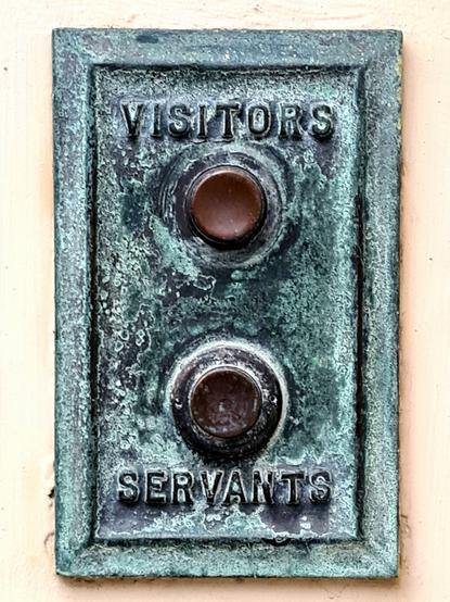 A doorbell platw with two buttons on it, one labelled Visitors and the other labelled Servants.