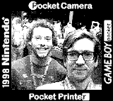 A retro 1-bit low-res photo of two people at a festival made with a 1998 Nintendo GameBoy camera, with signage around it