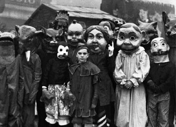 numerous costumed figures, many with oversized heads
