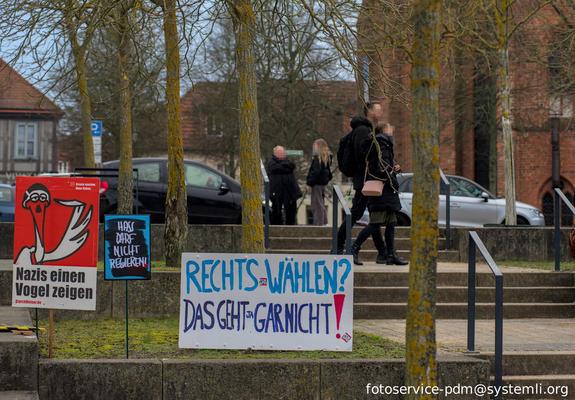 auf einem platz stehen mehrere protest schilder:
-ein storch der einen vogel zeigt mit der aufschrift: nazis den vogel zeigen"

-ein kleines schild mit der aufschrift : "hass darf nicht regieren"

- ein schild mit: "rechts wählen? das geht gar nicht"