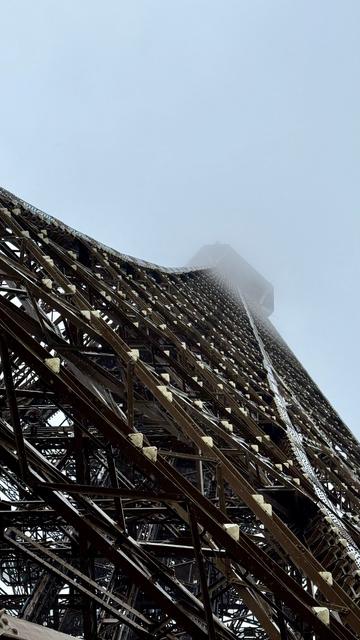 Blick von der zweiten Plattform hoch am Turm zur obersten Plattform, die im Nebel verschwindet. Man sieht die Konstruktion des Turms.