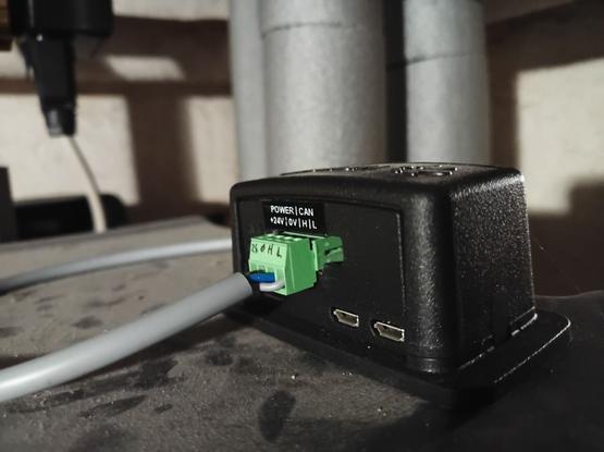 Ein RaspberryPi Zero2W in einem modifizierten HifiBerry-Gehäuse, Rückseite, Sichtbar der Anschluss mit Versorgunsspannung +24V / 0V / CAN_H / CAN_L, das graue Kabel führt in die Heizung.
