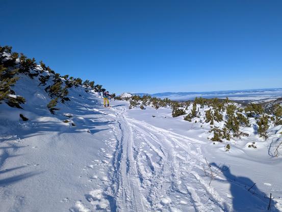 Ski track on the sunny snowy mountain slope.