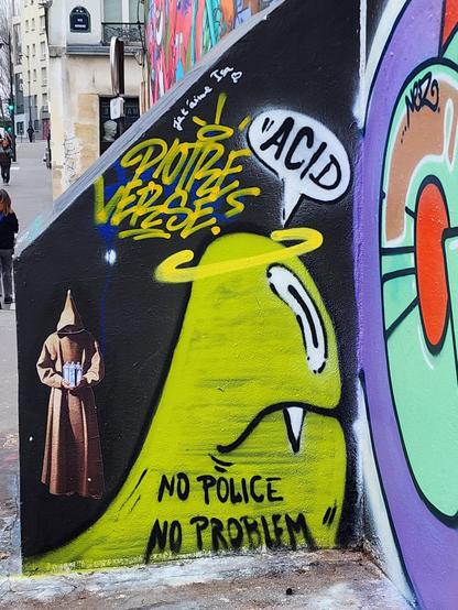 Green-yellow spray on black background showing a friendly ghost above his head stands a yellow holly-hollow a fang going down of his upper lip at floor level written in black spray little capitals NO POLICE NO PROBLEM
