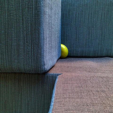 eine Pomelo versteckt sich in der Falte eines Design-Sitzmöbels