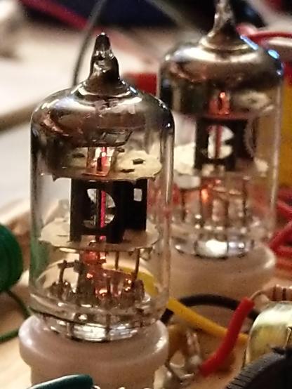 Closeup of the two vacuum tubes, glowing softly.