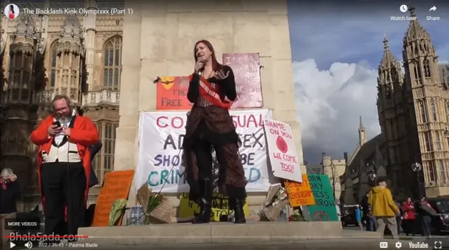 Video screengrab showing Pandora Blake speaking at a protest outside Parliament, in front of a sign reading Consensual Adult Sex Should Not Be Criminalised