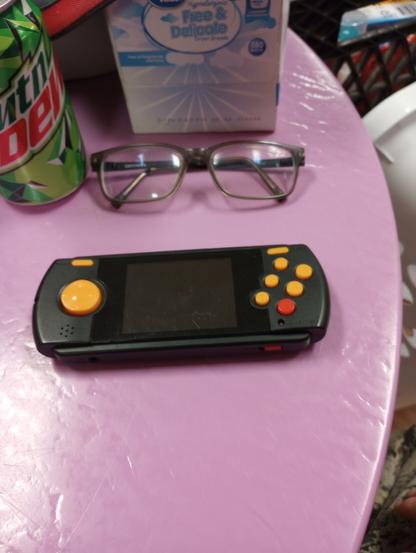 Atari Flashback Portable. Small black toy with a small screen, D pad on one side, and buttons on the other.
