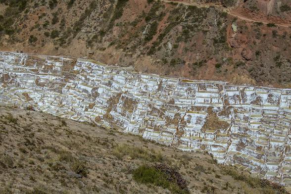 High angle view on the Salinas de Maras, Pre Inca traditional salt mine (salinas) in Peru.

Maras is a town in the Sacred Valley of the Incas, 40 kilometers north of Cuzco, in the Cuzco Region of Peru. The town is well known for its salt evaporation ponds, located towards Urubamba from the town center, which have been in use since Inca times.

The salt-evaporation ponds are four kilometers north of the town, down a canyon that descends to the Rio Vilcanota and the Sacred Valley of the Incas.