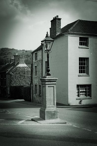 Junction in an old town with a lamppost in the middle.