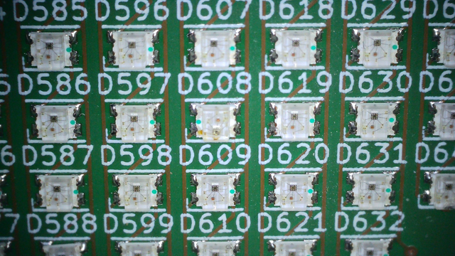 Close up of a green pcb. About 20 leds are visible, they are align in a grid with a label above each one.
On each led, there is a green dot on its right. 
Except one where the dot is on the left. Also, that led has burn mark :(