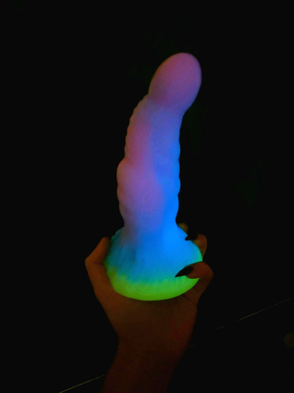 i'm holding a dragon dildo in the dark. it's glowing a soft blue and purple