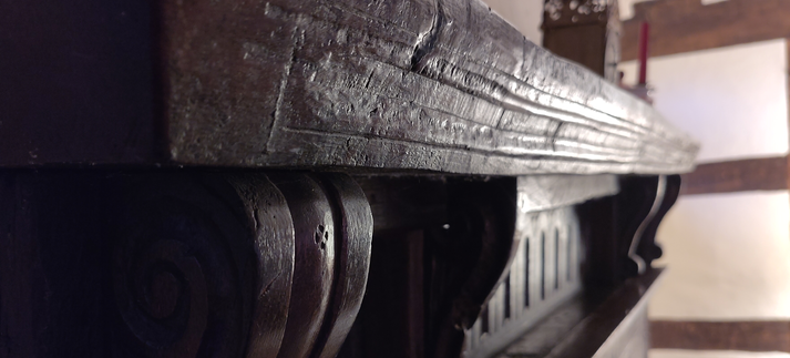 Close up of dark wooden mantelshelf in oak carved 600 years ago
