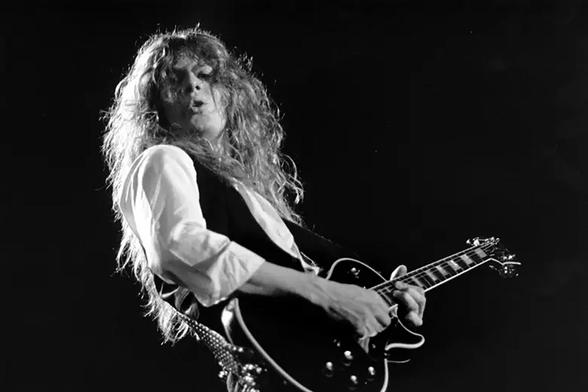 Black and white shot of guitarist John Sykes playing a black Les Paul