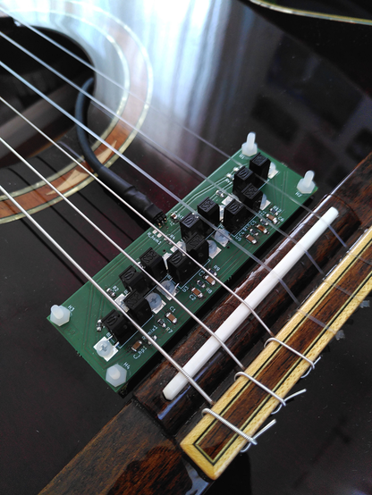 A photo of the pickupinstalled on a guitar. It has a photointerrupter for each string.
