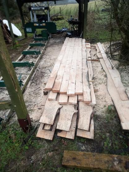A pile of waney edged weatherboarding and square cut decking beside the sawmill bed.