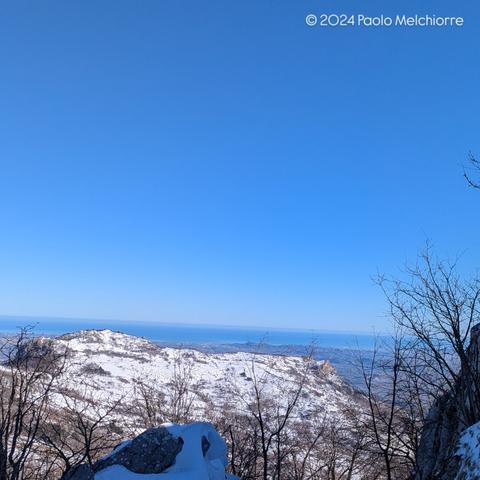 Snow-capped Mount Bertone, seen from Voltigno, on the Gran Sasso mountain range, with the sunny Adriatic Sea in the background.