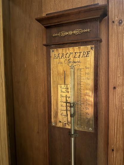 Upper part of a mercury barometer. A glass rod filled with mercury is shown, along with milimeter graduations and weather indications.
