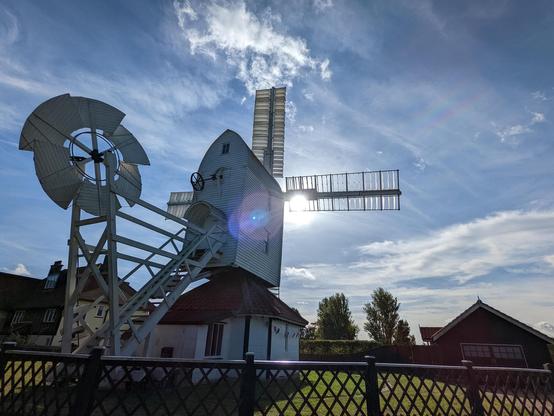 White windmill partially silhouetted against the sky.