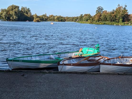Boating lake on the Mer, Thorpness. Three rowboats lay on the shore in the foreground.